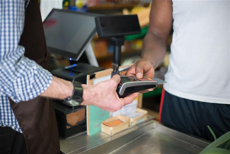 homem fazendo um pagamento na maquina de cartao de credito