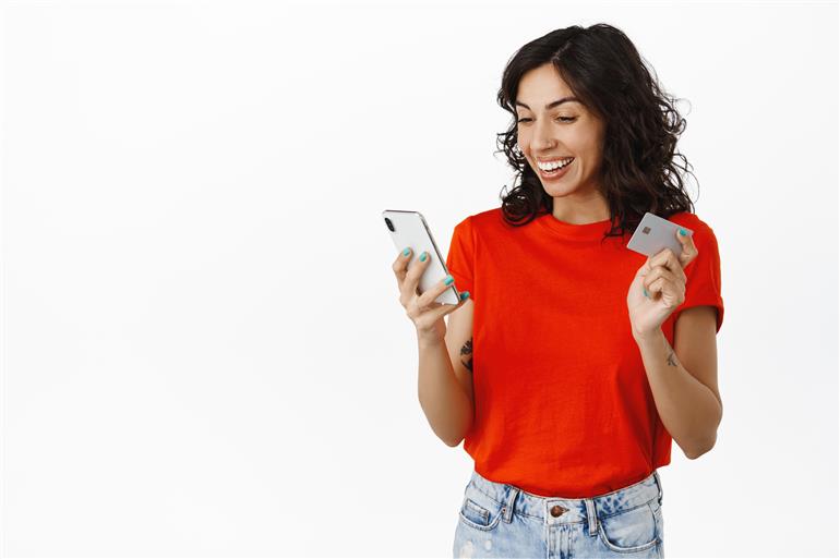mulher feliz segurando o celular e o cartao de credito
